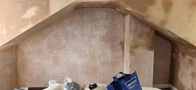 Plasterer smoothing a wall finish in a Bridgend home
